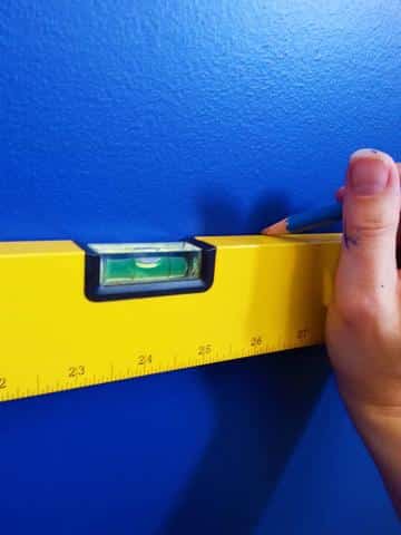 Use a level to draw a pencil line on the wall.