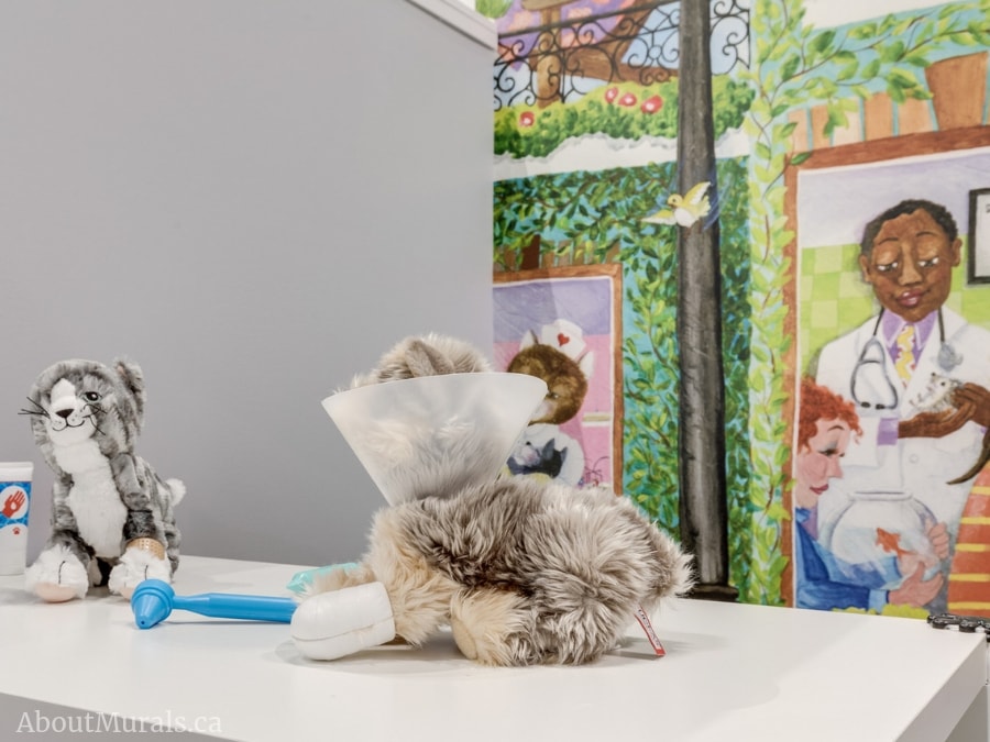 A stuffed animal poses in front of Animal Hospital Wall Mural, which features a cat, bird and fish at the vet. Kids wallpaper sold by AboutMurals.ca.