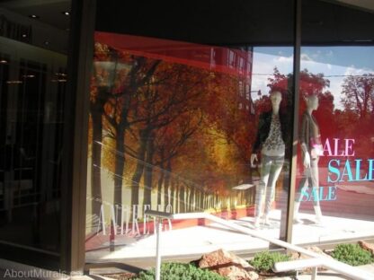 Autumn Colors Wall Mural, as seen in this retail store, features a red and yellow trees lining a winding lane. Forest wallpaper sold by AboutMurals.ca.