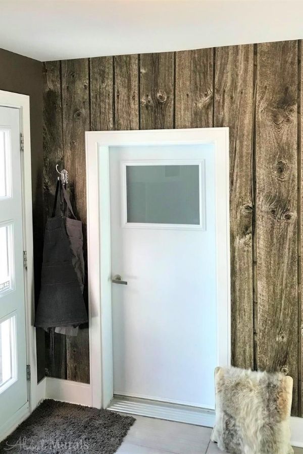 Barn Wood Wallpaper, as seen on the wall of this foyer, features brown reclaimed wooden planks. Faux wood wallpaper sold by AboutMurals.ca.