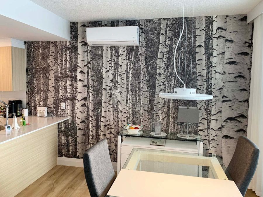 Black and White Birch Tree Wallpaper, as seen on the wall of this kitchen, is a photo mural of vintage trees in a grey forest from About Murals.