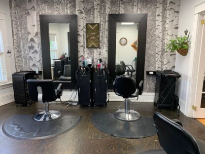 Black and White Birch Tree Wallpaper, as seen on the wall of this salon, is a photo mural of vintage trees in a forest from About Murals.