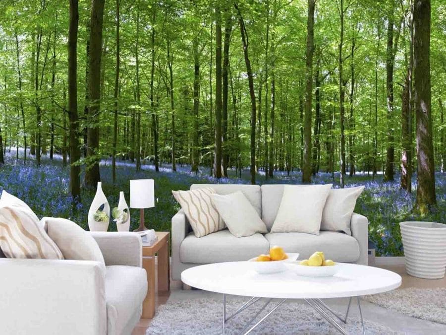 Bluebell Forest Wallpaper, as seen on the wall of this beige living room, features a bed of flowers under a spring forest from About Murals.