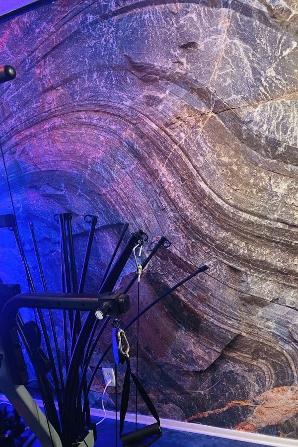 Canadian Shield Swirl Wall Mural, as seen on the wall of this gym, is a photo wallpaper of a realistic rock wall from About Murals.