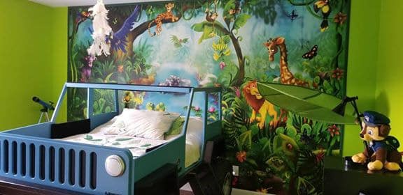 Jungle Wall Mural, as seen in this boy bedroom behind a jeep bed, is an animal wallpaper in the rainforest from About Murals.