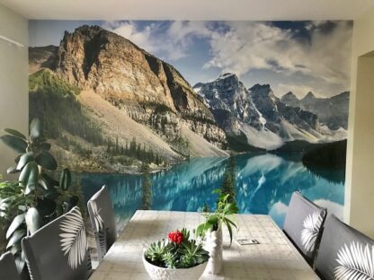 Moraine Lake Wallpaper, as seen on the wall of this kitchen dining room, is a photo mural of mountains overlooking a blue lake from About Murals.