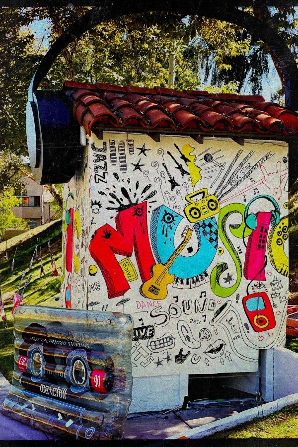 Musical Wall Mural, as seen on this music themed school event prop, is a kids wallpaper with the word "Music" in a graffiti style with music themed doodles from About Murals.