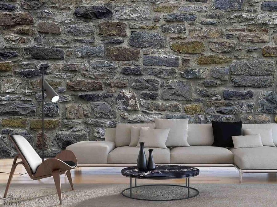 Stone Wall Mural, as seen in this rustic living room, is a photo wallpaper of real looking stones in grey, moss green and periwinkle from About Murals.