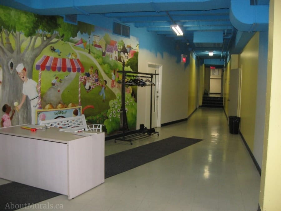 Sunday at the Park Wall Mural, as seen on the wall of this church, features children eating ice cream, flying a kite, having a picnic and walking near a pond. Kids wallpaper sold by AboutMurals.ca.
