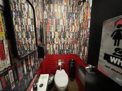 Commercial wallpaper installation by Adrienne of About Murals in a restaurant bathroom in a vintage VHS design