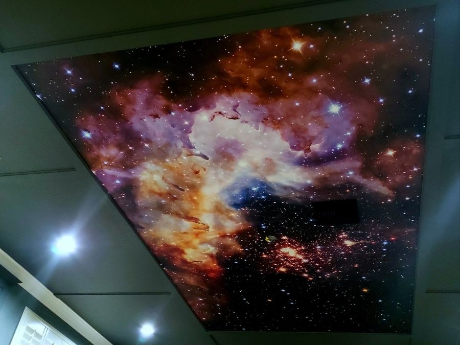A custom wallpaper, as seen on this ceiling, features a starry outer space sky from About Murals