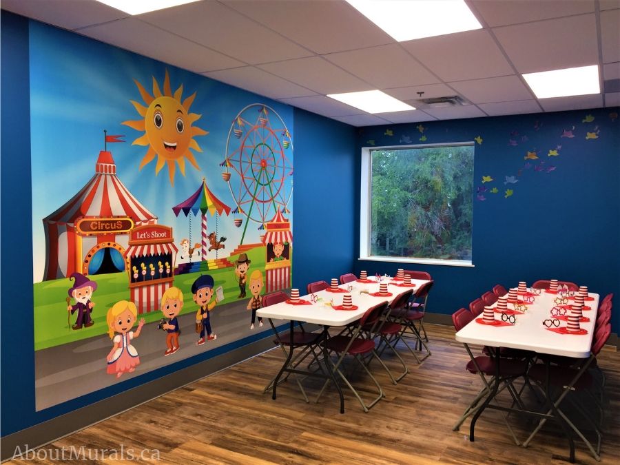 Custom wallpaper, as seen on the wall of this birthday party room, is a kids mural with a circus tent, ferris wheel and carousel from About Murals.
