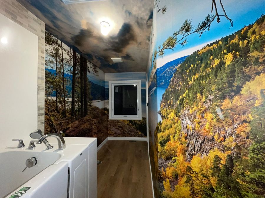 Personalized wall mural, as seen in this bathroom, with a sky ceiling mural and forest mural custom printed by About Murals.