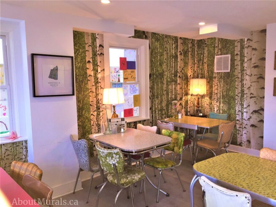 Green Birch Wallpaper, as seen on the wall of Pete & Kay Diner, creates a vintage feel behind antique diner tables. Forest wallpaper sold by AboutMurals.ca.