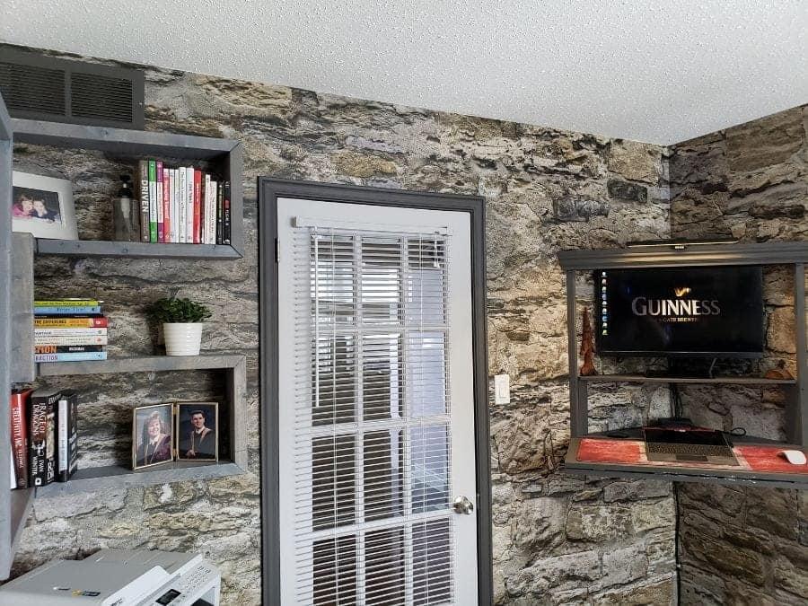Castle Stone Wallpaper, as seen on the wall of this entertainment room, is a high quality photo mural of beige stones from About Murals.