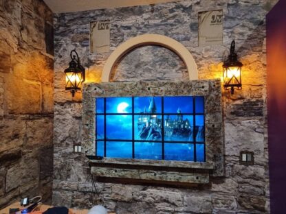 Castle Stone Wallpaper, as seen on the wall of this Harry Potter room with a faux window looking at Hogwarts Castle, is a high resolution photo wall mural of textured brown and beige stones from About Murals.