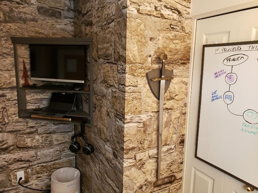 Castle Stone Wallpaper, as seen on the wall of this rustic office, is a high res photo mural of brown stacked stone from About Murals.