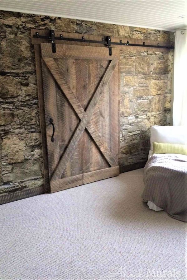 Castle Stone Wallpaper, as seen in this rustic room, features a wall of textured brown rock. Buy easy wallpaper from AboutMurals.ca.