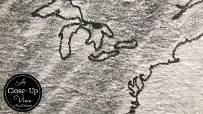 A close-up view of textured gray world map wallpaper from About Murals