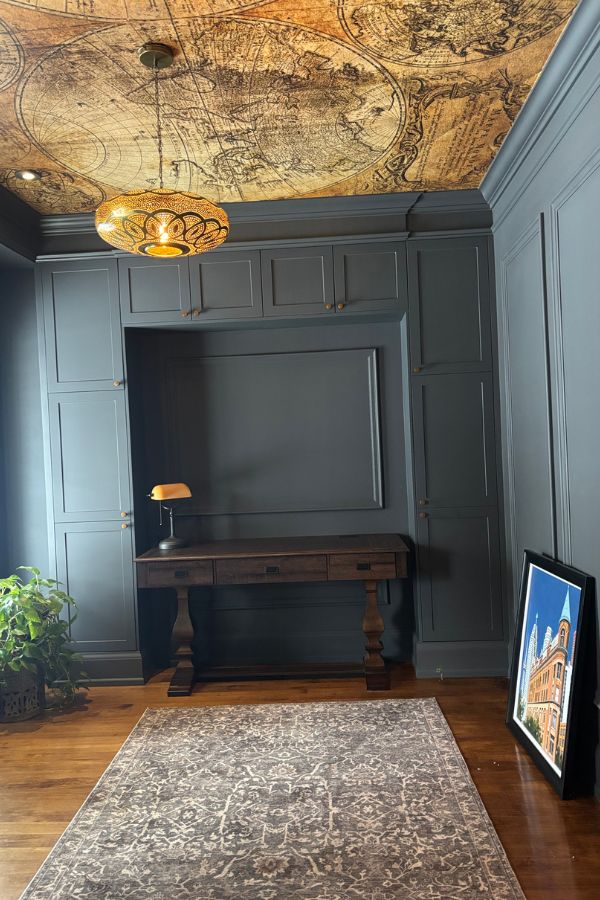 Old World Map Wallpaper, as seen on the ceiling of this office, is a wall mural with a vintage double hemisphere design from About Murals