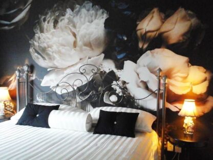 Black Floral Wallpaper, as seen on the wall of this elegant bedroom, is a photo mural of a bouquet of roses and peonies on a dark background from About Murals.