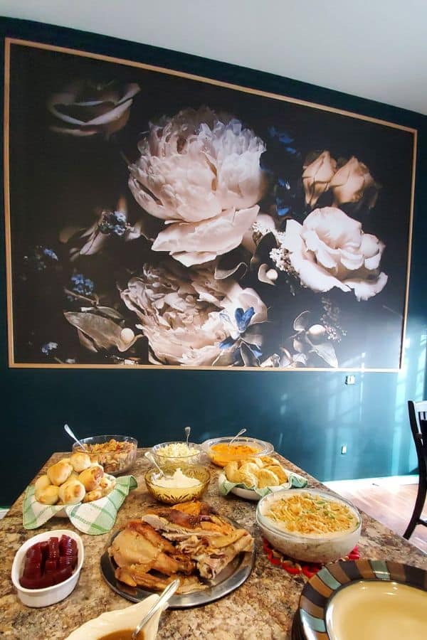 Black Floral Wallpaper, as seen on the wall of this entertaining lounge, is a mural with peonies and roses against a dark backdrop from About Murals.