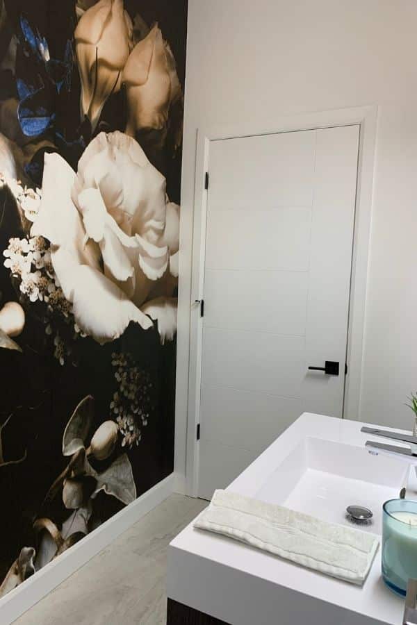 Black Floral Wallpaper, as seen on the wall of this powder room, is a photo mural of a white rose and blue flower on a dark background from About Murals.