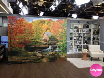 Watermill Wallpaper, as seen on set at Cityline TV, is a high resolution photo mural of Glade Creek Grist Mill in Virginia overlooking a waterfall underneath red and yellow autumn trees from About Murals.