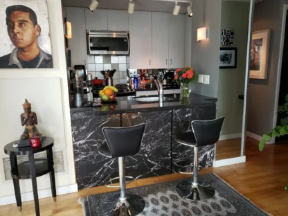 Black Marble Wallpaper, as seen on the front of a home bar in a kitchen, is a photo mural of black marble with white veins from About Murals.