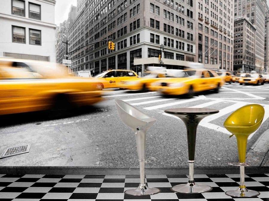 New York Yellow Taxi Wallpaper, as seen on the wall of this dining room, features yellow cabs driving past grey buildings in NYC from About Murals.