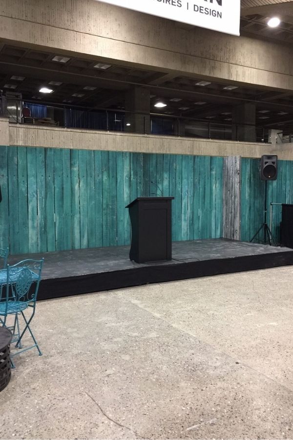 Turquoise Wood Wallpaper, as seen on the wall of this tradeshow booth, features blue wooden planks from About Murals.