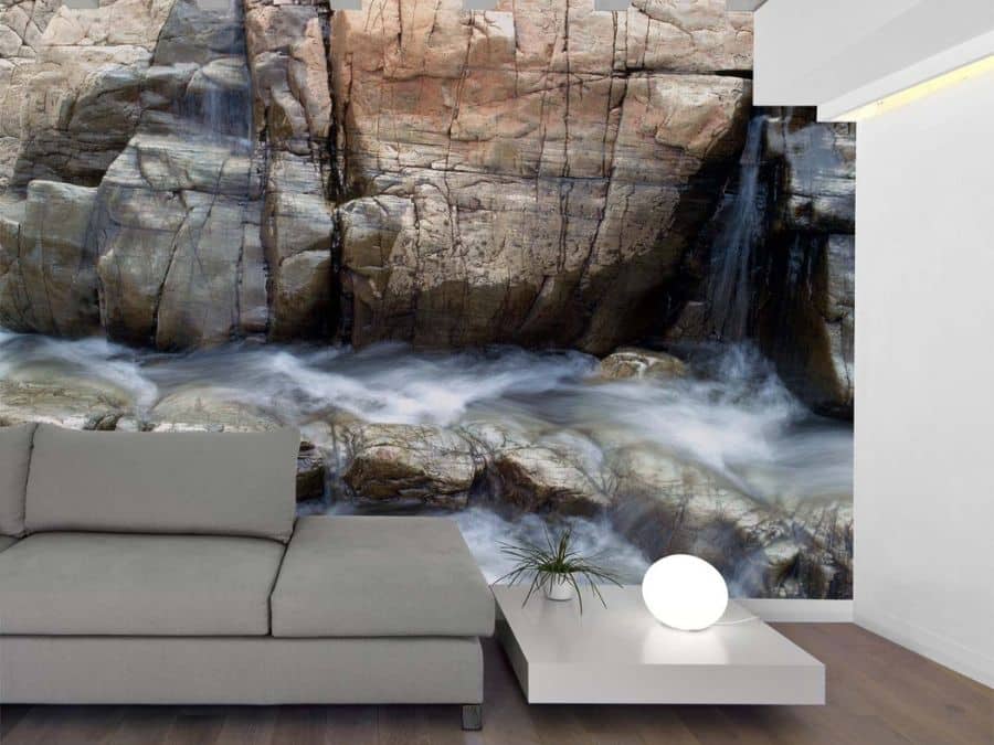 Flowing Water Wallpaper, as seen on the wall of this living room, is a photo mural of falls pouring over brown mountain rock from About Murals.