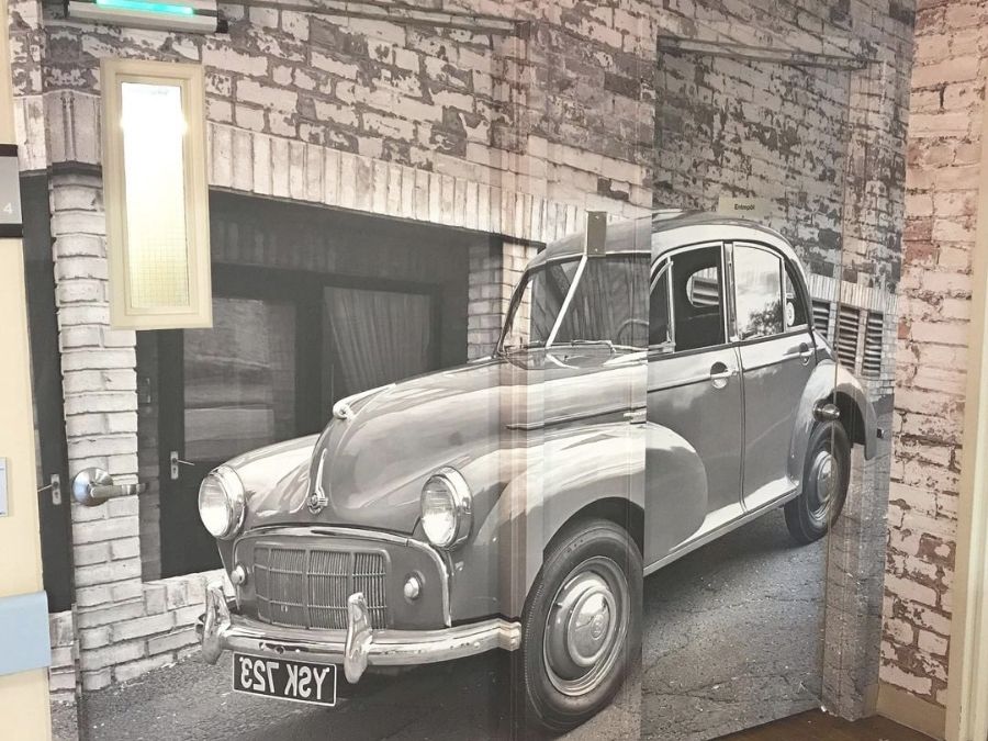 Grunge Brick Wallpaper, as seen on the wall with this vintage mural, is a photo mural of white paint decaying on red brick from About Murals.