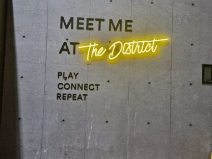 Concrete Wallpaper, as seen on the wall of this sports facility and pickleball club called The District, is a high resolution photo mural of a real concrete wall that creates a modern, industrial feeling from About Murals