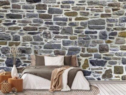 Country Stone Wallpaper, as seen on the wall of this bedroom, is a high resolution photo mural of blue, green and grey stones that adds a realistic texture to rooms from About Murals.