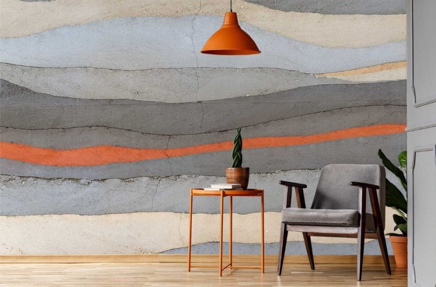 Grey and Orange Concrete Wallpaper, as seen on the wall of this sitting room, is a photo wallpaper of a horizontal orange painted stripe across a concrete wall from About Murals.