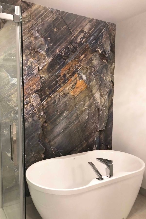 Rock Texture Wallpaper, as seen on the wall of this bathroom, is a photo mural of a colorful rock face wall from About Murals.