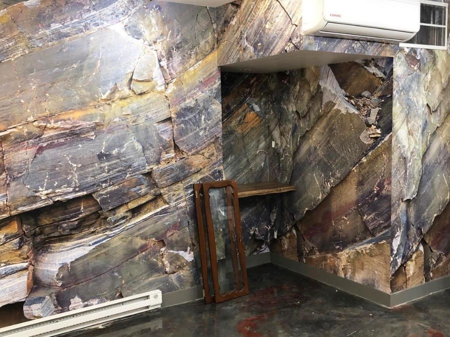 Rock Texture Wallpaper, as seen on the wall of this office, is a photo mural of a rock face wall from About Murals.