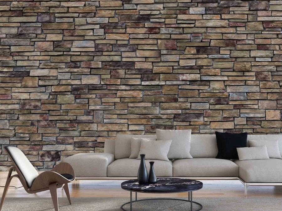 Stacked Stone Wallpaper, as seen on the wall of this living room, is a high resolution photo mural of grey and brown rectangular stones that create a texture look from About Murals.