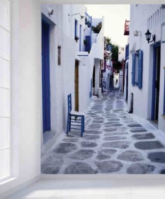 Mykonos Wallpaper, as seen on the wall of this room, features a cobblestone alley lined with whitewashed architecture on Matoyianni Street in Greece from About Murals.