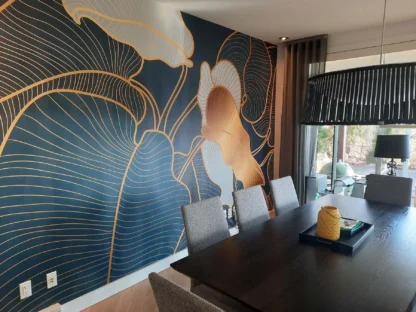 Philodendron Wallpaper, as seen on the wall of this dining room behind a table, is a tropical leaf mural with blue foliage from About Murals.