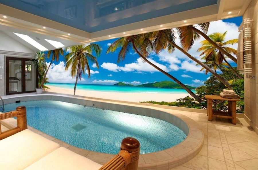 Beautiful Beach Wallpaper, as seen on the wall of this ocean themed room, is a photo mural of palm trees looking over a blue ocean and green islands on the horizon from About Murals.