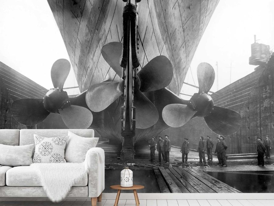 Titanic Wallpaper, as seen in this ship themed living room, is a black and white photo mural of men inspecting massive propellers of the Titanic in dry dock from About Murals.