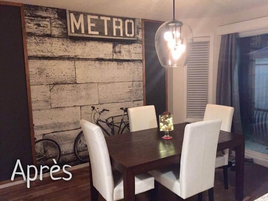 Bicycle Wallpaper, as seen on the wall of this dining room, is a black and white photo mural of two bikes leaning against a brick wall under a Paris Subway Metro sign from About Murals.