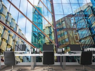 Building Wallpaper, as seen on the wall of this office, is a photo mural of skyscrapers reflected in gray glass panes from About Murals.