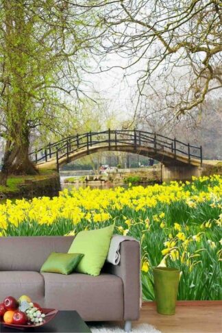 Daffodil Wallpaper, as seen on the wall of this living room, is a photo mural of a bridge in an English Park overlooking a pond and yellow flowers from About Murals.