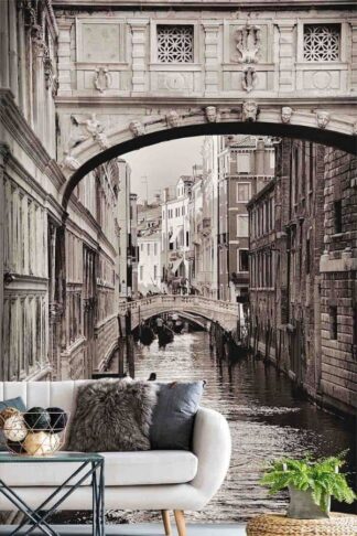 Venice Wallpaper, as seen on the wall of this living room, is a photo mural of a gondolier rowing a gondola boat on a canal under the Bridge of Sighs from About Murals.