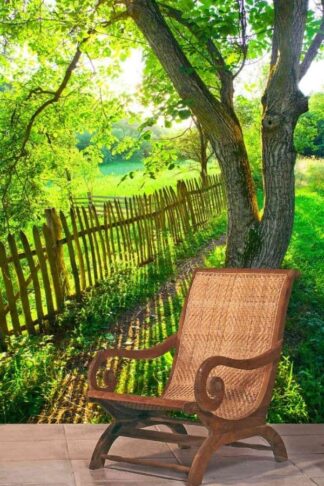Wooden Fence Wallpaper, as seen on the wall of this room, is a photo mural of a sun setting through green trees, a grassy field and a picket fence from About Murals.