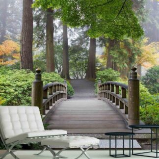 Autumn Bridge Wallpaper, as seen on the wall of this living room, is a photo mural of a wooden bridge surrounded by autumn trees in a forest from About Murals.