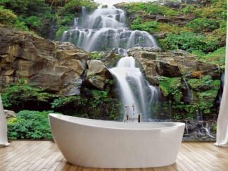 Beautiful Waterfall Wallpaper, as seen on the wall of this bathroom, is a photo mural of white water cascading over rocks surrounded by tropical foliage and plants from About Murals.